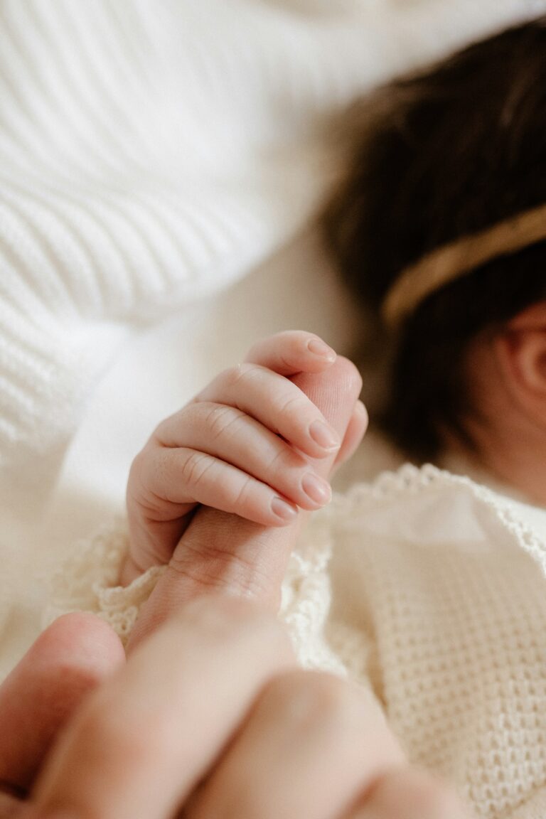 neonata stringe la mano della sua mamma