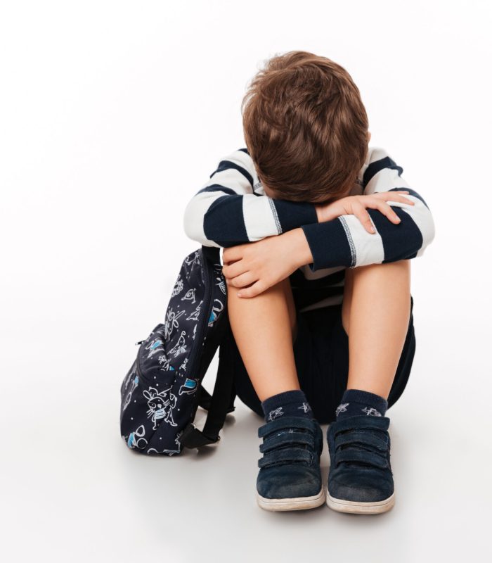 mio figlio è un bullo, bambino triste accovacciato a terra