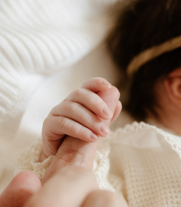 neonata stringe la mano della sua mamma