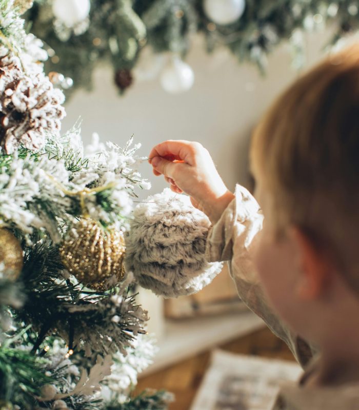 bambino addobba l'albero di Natale
